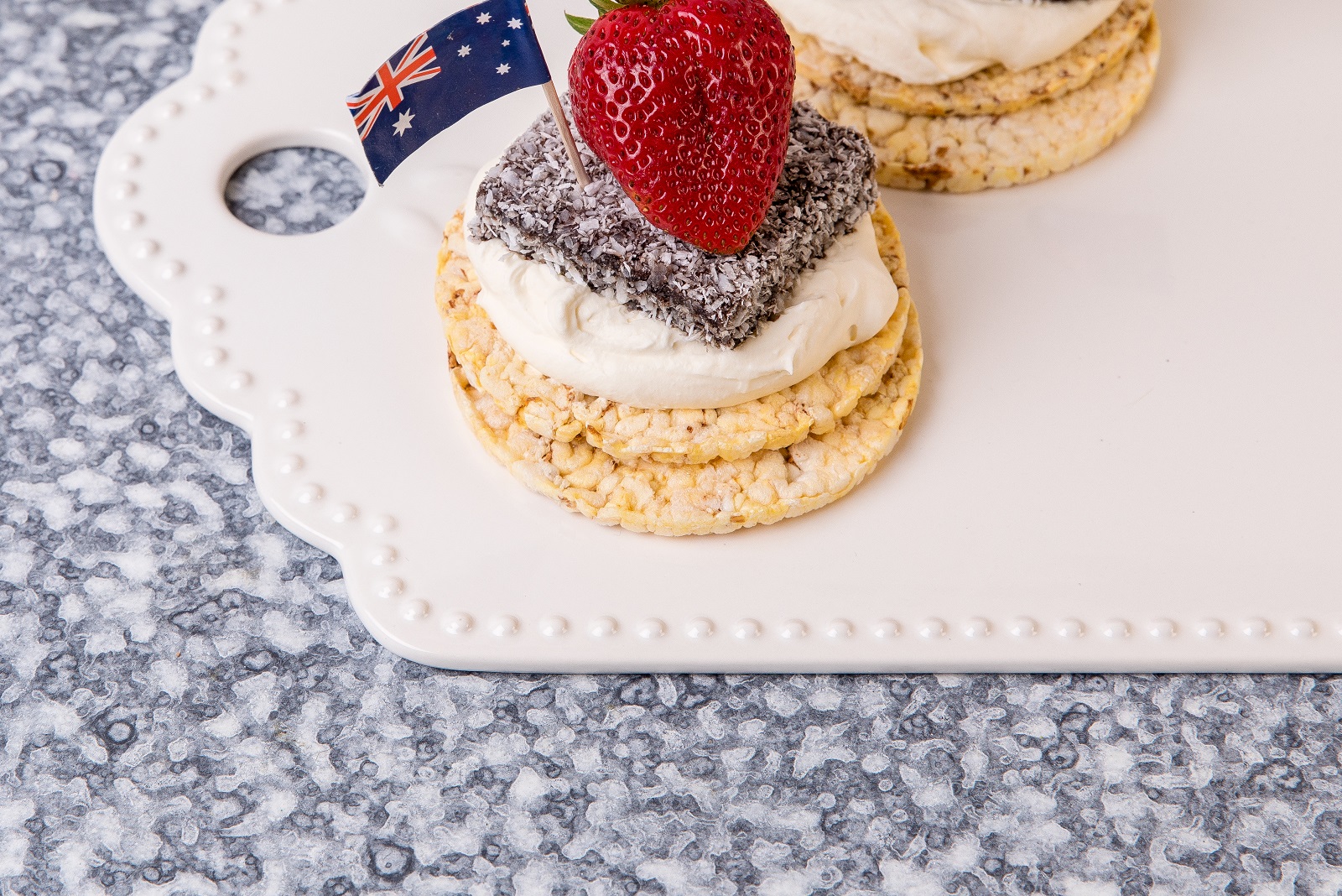 Whipped cream, lamington & strawberry on Corn Thins slices