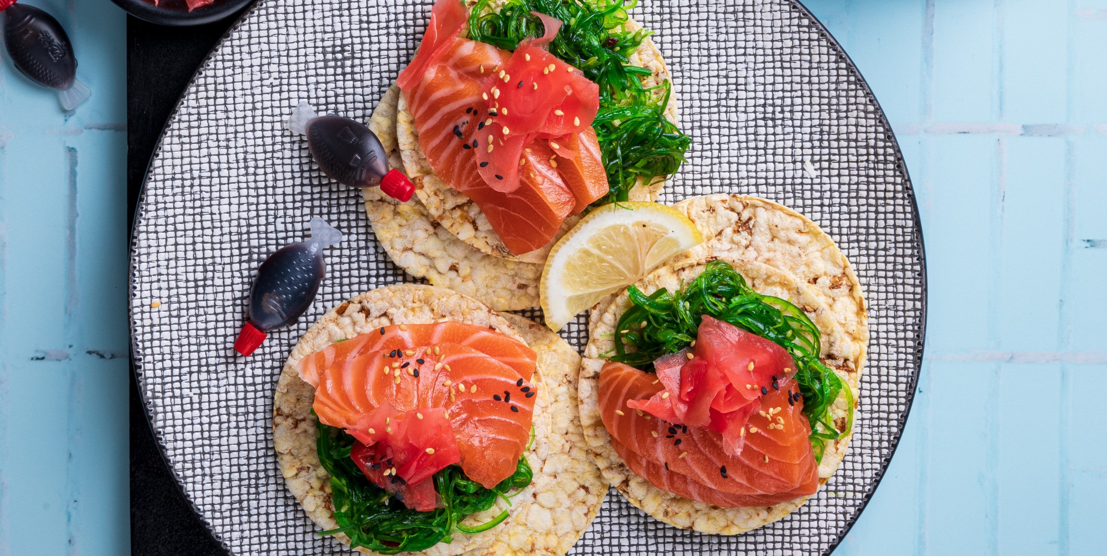 Seaweed salad, salmon sashimi, pickled ginger & sesame seeds on Corn Thins slices