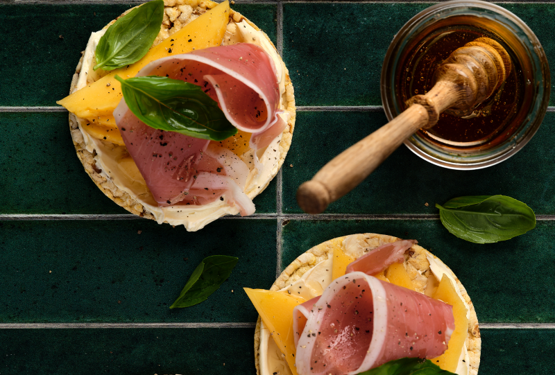 Cream Cheese, Mango, Prosciutto, Pepper, Honey & Basil on Corn Thins slices