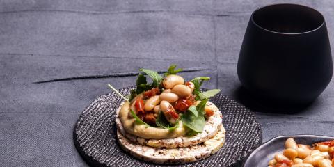 Hommos, rocket, white beans & sundreied tomato on Corn Thins slices