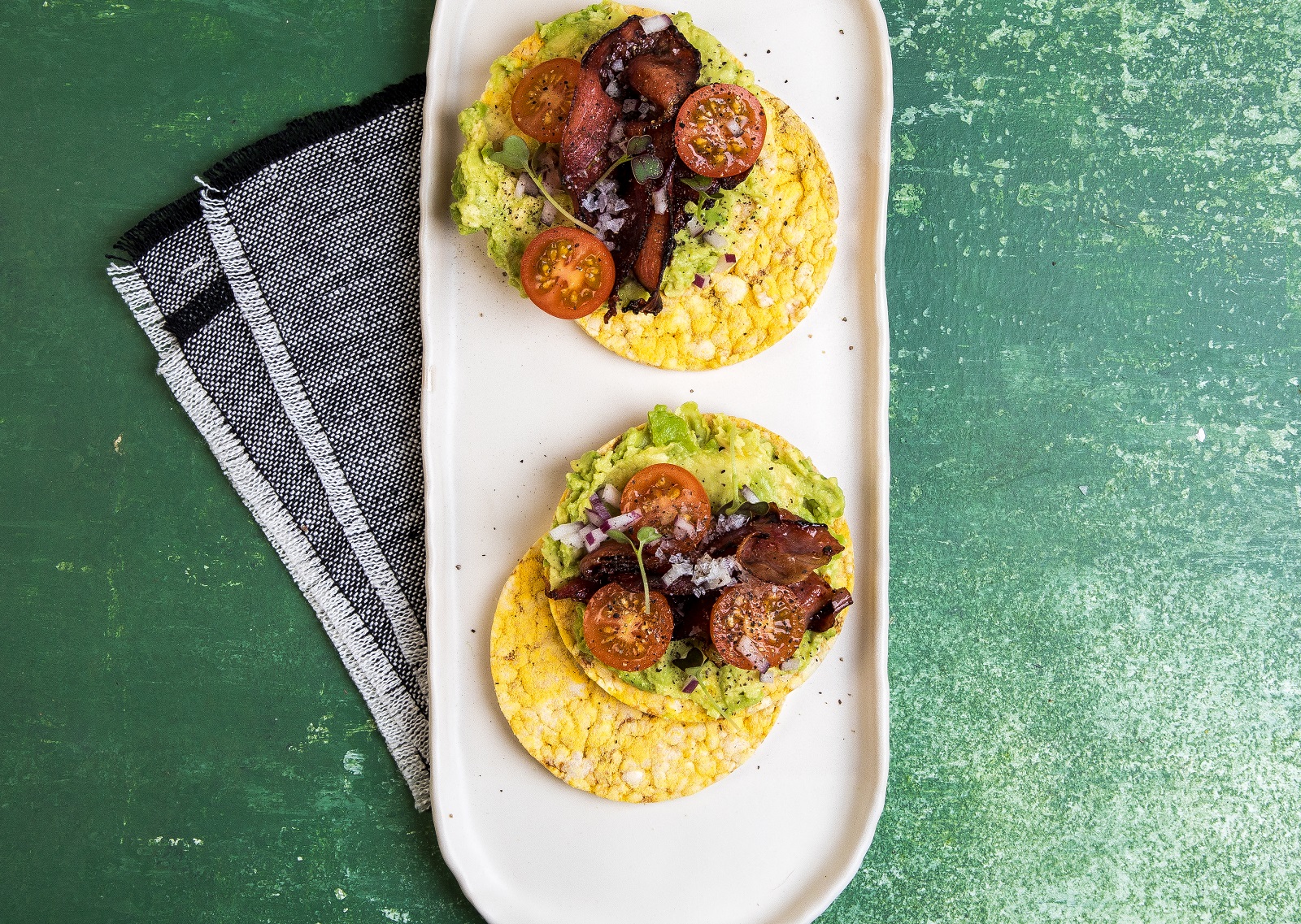 Avocado smash, with bacon, tomato & onion on CORN THINS slices