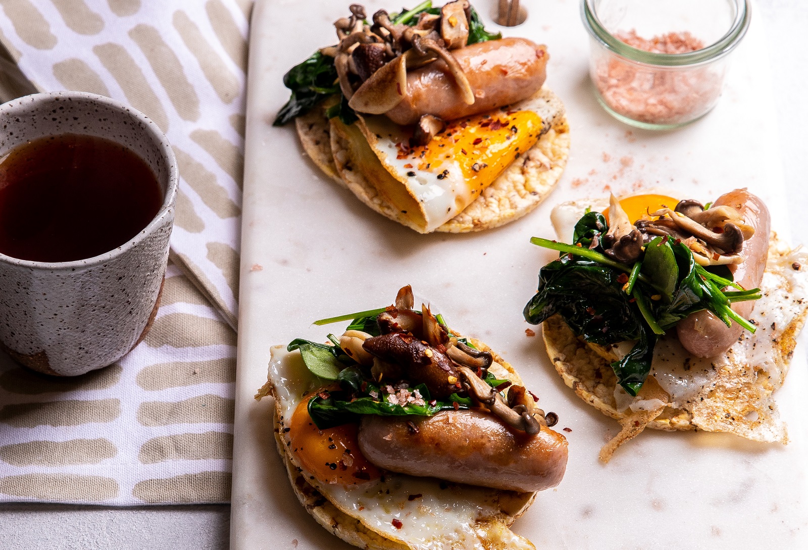 A big breakfast of Fried Egg, Sausage, Mushroom & Spinach on Corn Thins slices