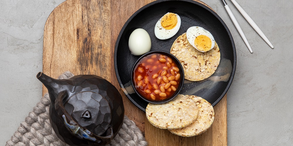 Beans & boiled egg on Corn Thins slices for breakfast