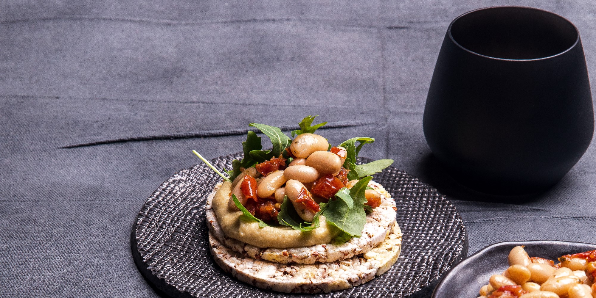 Hommos, rocket, white beans & sundreied tomato on Corn Thins slices